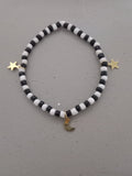 Black and white beaded bracelet with gold star and moon charms