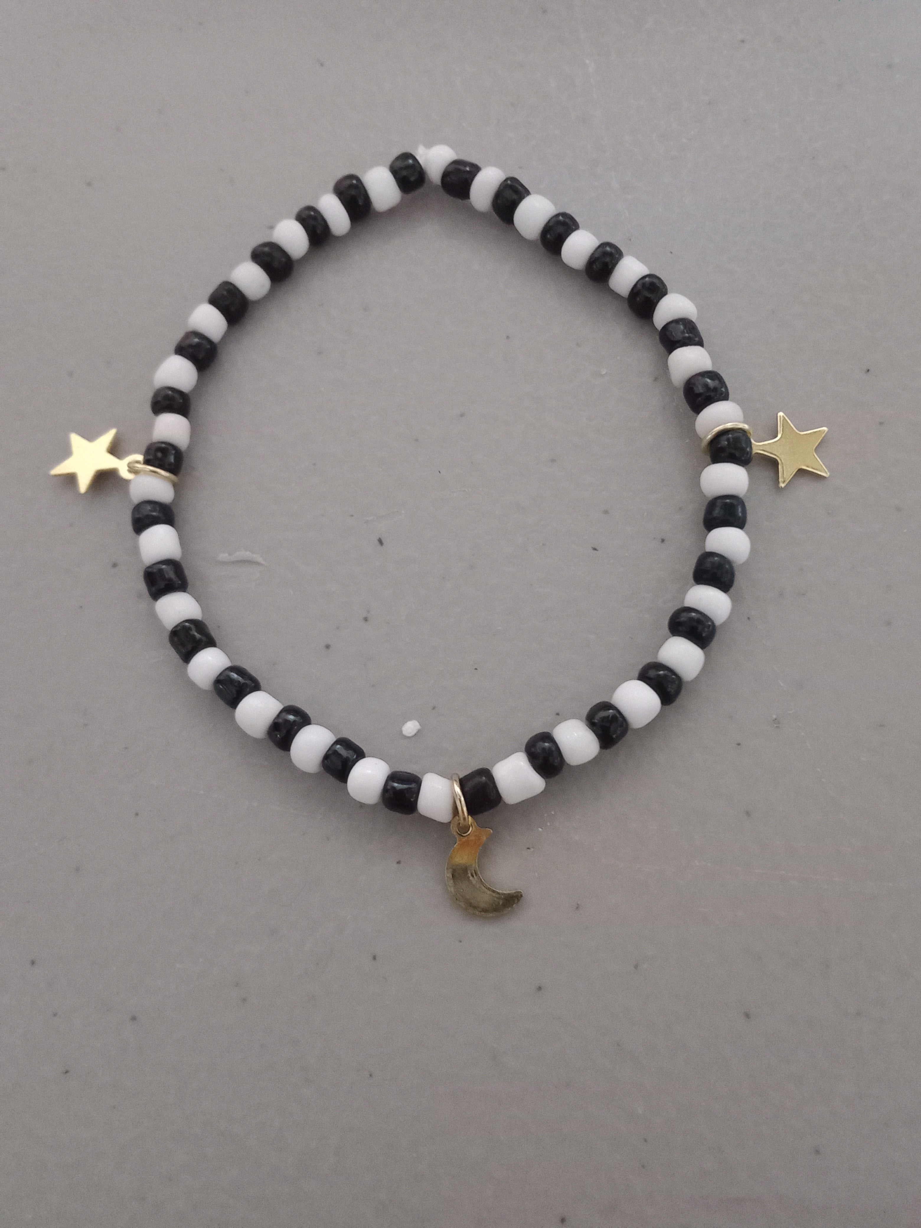 Black and white beaded bracelet with gold star and moon charms